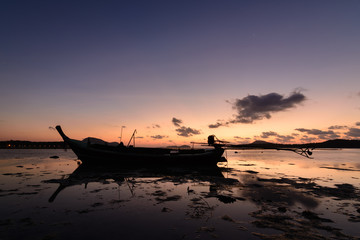 Traditional Thai longtail boat at sunrise beach in Phuket, Thailand