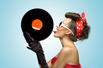 The vinyl desire / A photo of glamorous girl touching vinyl disk with tongue.