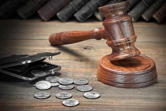 Gavel, Empty Purse, Coins, And Old Book On Wooden Table
