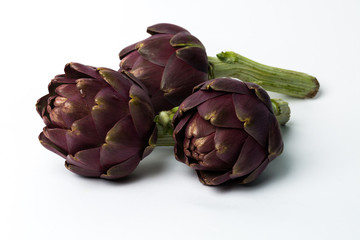 Obraz premium Three fresh roman artichokes isolated on white background