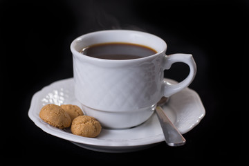 white porcelain cup of hot coffee, espresso with three Italian amaretti cookies