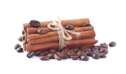 Палочки корицы и кофейные зерна на белом фоне