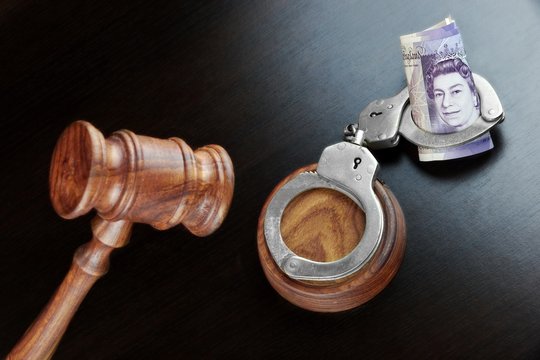 Judges Gavel, Handcuffs And  British Cash  On The Black Table
