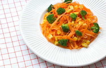healthy fresh carrot salad with pieces of broccoli and corns