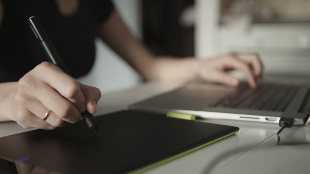 woman designer draws on a graphics tablet