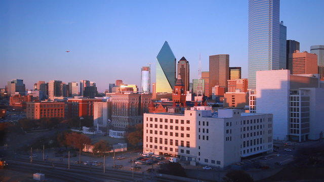 Slight pan of Dallas skyline and trainyard during sunset