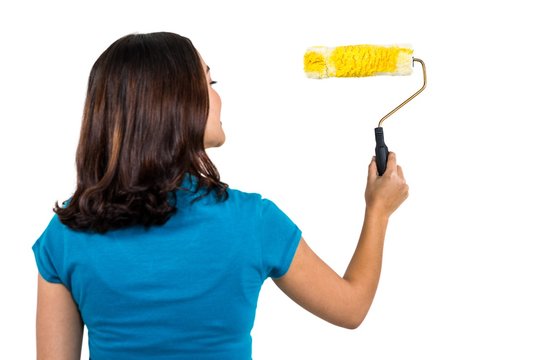 Rear View Of Woman Holding Paint Roller 