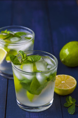 Glasses of lemonade with mint leaves and ice cubes