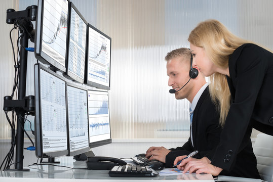 Business People Analyzing Data Displayed On Computer Screens