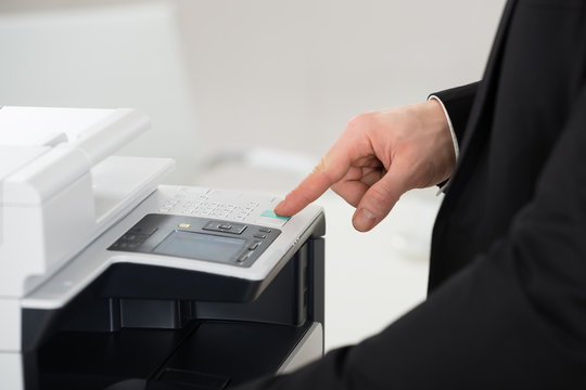 Businessman Operating Printer In Office