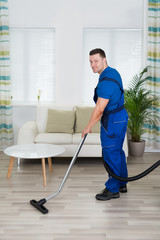 Worker Cleaning Floor With Vacuum Cleaner