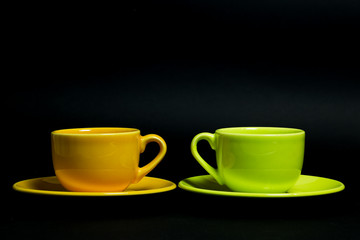 Two coffee cups on a black background
