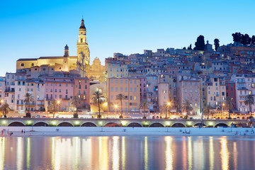Menton, old city illuminated in the evening, light reflections