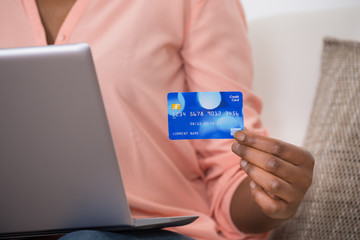 Woman Holding Debit Card For Online Shopping On Laptop
