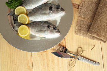 raw fish silver tray on wooden background pine
