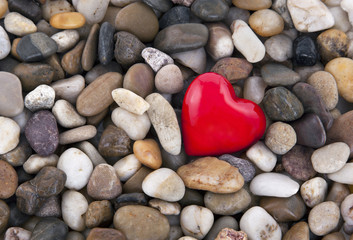 Red heart on pebbles background
