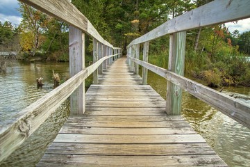 Bridge Over Water. Footbridge over water diminishing into the autumn forest. Ludington State Park. Ludington, Michigan.