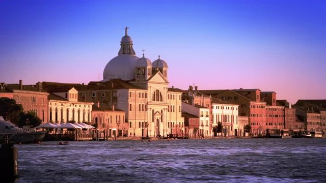 Slow motion, panning shot of the Bauer Palladio Hotel from across the waterway