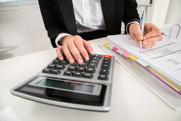 Businesswoman Doing Financial Calculation At Desk