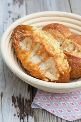 Two fresh backed buns - with cheese and salt in wooden bowl on wooden table. Fresh and hot, perfect for your meal - your lunch or breakfast. Natural light, selective focus.