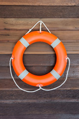 Оrange lifebuoy on wooden wall