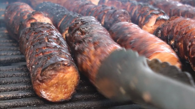Cooking cut polish sausages on the fire pit's grill
