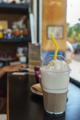 Iced coffee cup on wooden table in coffee shop