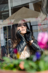 Woman with a unique fleshy lips wearing leather jacket and gloves photo taken through the glass