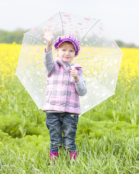 little girl with umbrella in spring nature