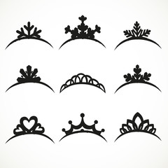 Set of silhouettes of tiaras of various shapes on a white backgr © Azuzl