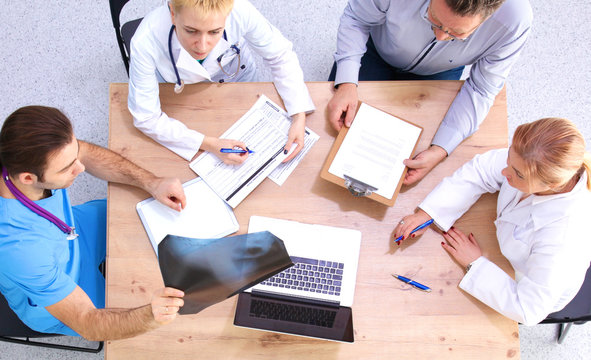 Male and female doctors working on reports in medical office