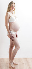 standing pregnant woman wearing lingerie