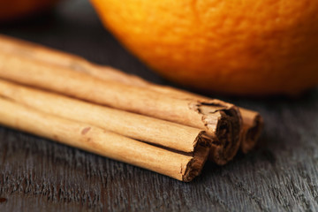 ripe oranges with cinnamon on wooden table