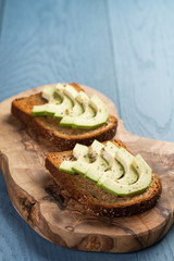 toasted rye bread with sliced avocado and herbs
