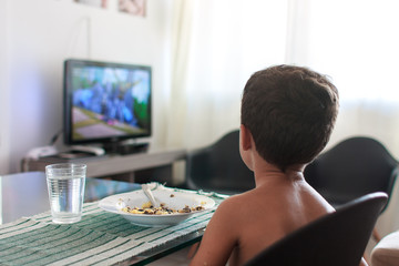 Child distracted watching tv eating lunch