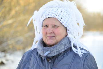 elderly woman in  white knitted shawl on her head 