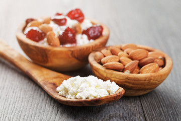 cottage cheese with preserved strawberry in wood bowl on oak table