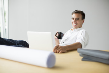 Young man drinking coffee in the office
