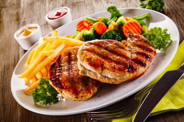 Grilled steaks, French fries and vegetable salad 
