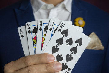 man holding card royal straight flush