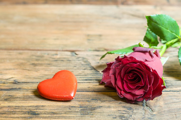 Róża i czerwone serduszko na drewnianym tle © Mike Mareen