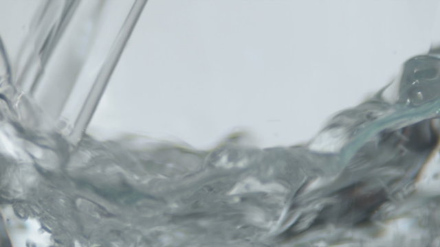 Extreme close up of water filling up an empty glass