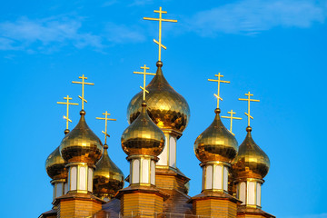 Fototapeta na wymiar Golden domes of Russian Orthodox wooden church