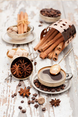 Cup coffee and spices in vintage silver cup on a wooden background