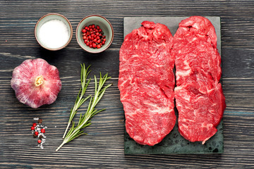 Raw ribeye steak, spices and herbs