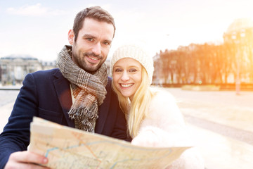 Couple of young attractive tourists watching map