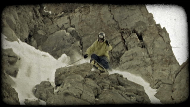 Expert skier jumps off rocky hill. Vintage stylized video clip.