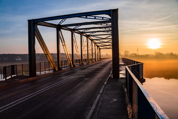 Konstrukcja mostu na tle wschodzącego słońca