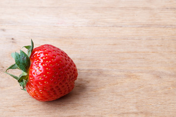Red fresh strawberry fruit on wooden table.