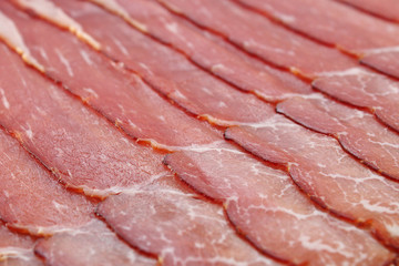 Slices of prosciutto ham. Background.